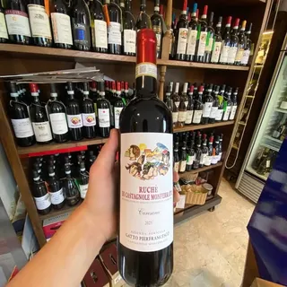 Scaffali di bottiglie nella cantina e una bottiglia di Ruchè di Castagnole Monferrato